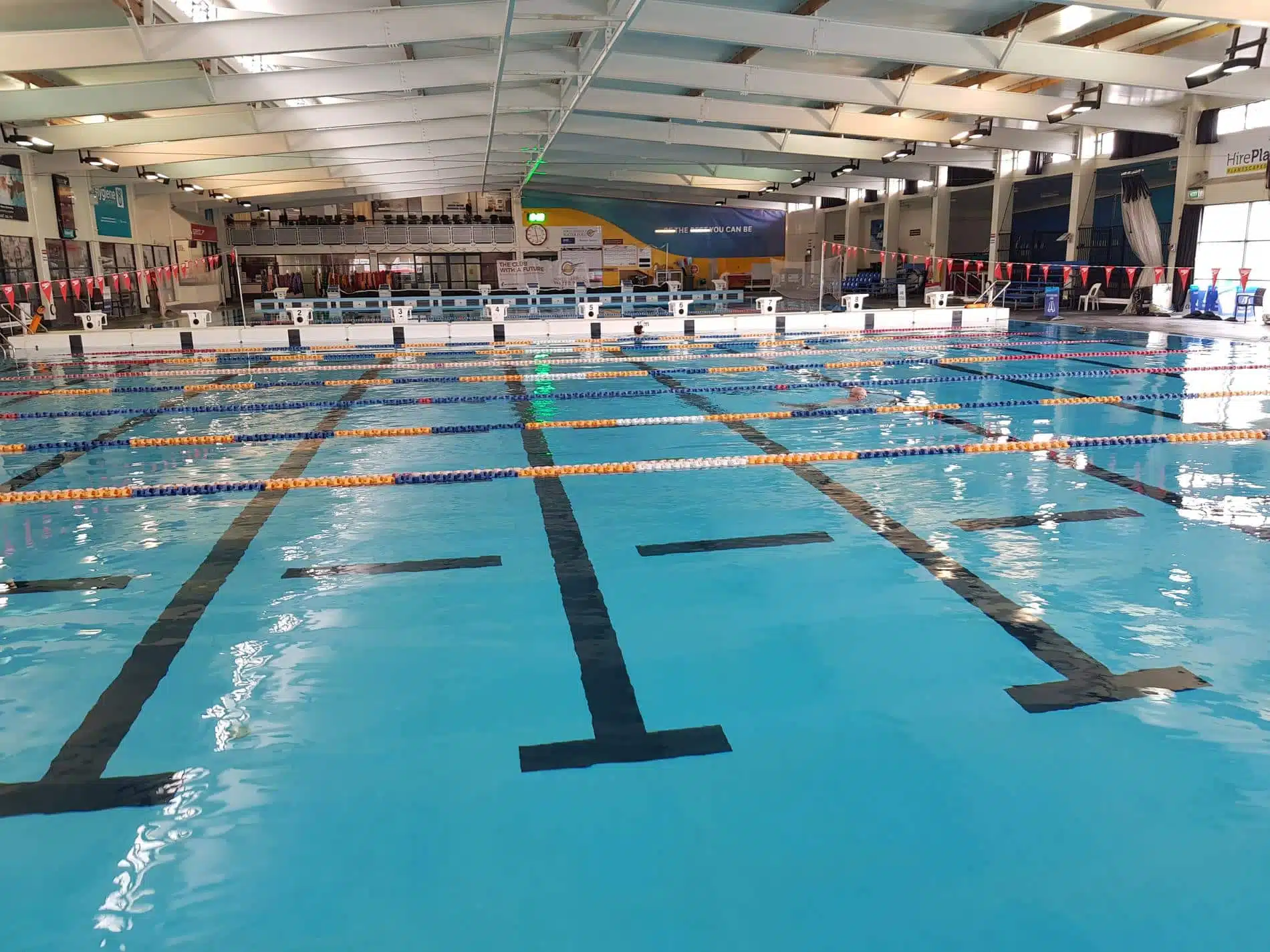 Indoor swimming pool at AUT Millennium in Auckland with bright blue lanes and clear water